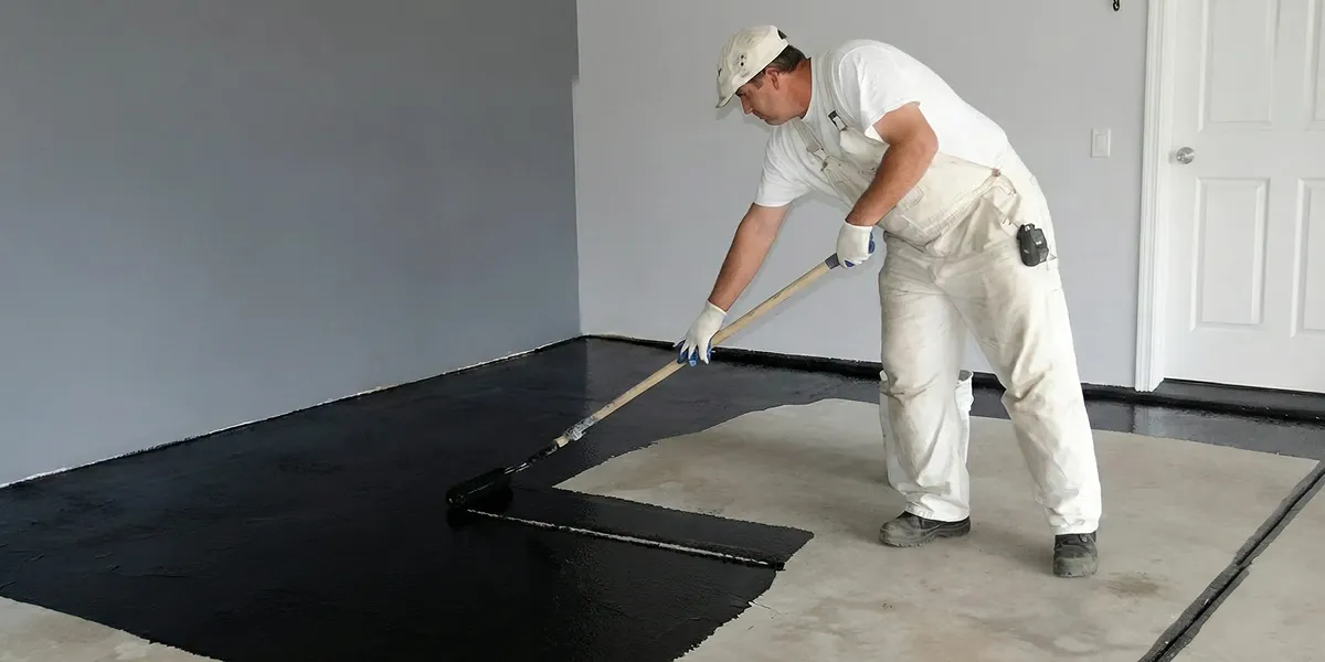 basement waterproofing professional applying waterproof coating to protect a basement floor in Green Bay, WI